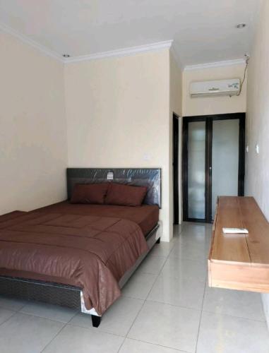 a bedroom with a bed and a wooden table at Sulfat Indah home stay syariah in Ngadipuro