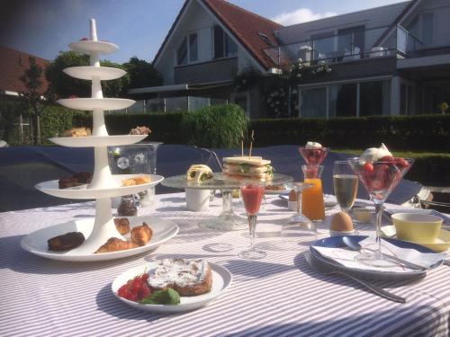 een tafel met borden met eten en drinken bij Villa Envie in Terherne