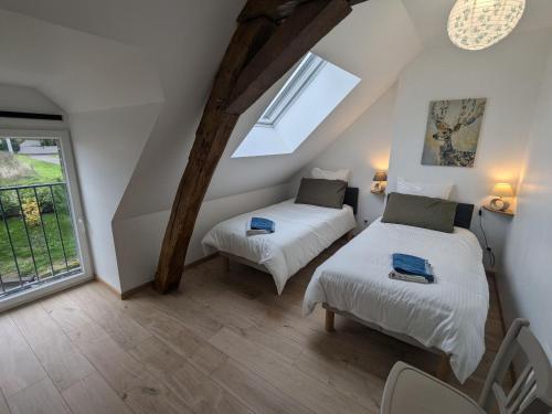 a attic room with two beds and a window at Charmant gîte près d'Orléans avec jardin privatif et parking - FR-1-590-524 in Chaingy