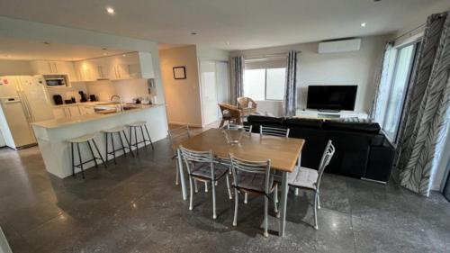 a kitchen and living room with a table and chairs at 1 - 5a Coochin Street, Dicky Beach - 200m To Beach in Caloundra