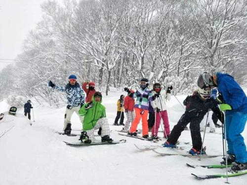 a group of people on skis in the snow at Hotel Tae Windsor in Myoko