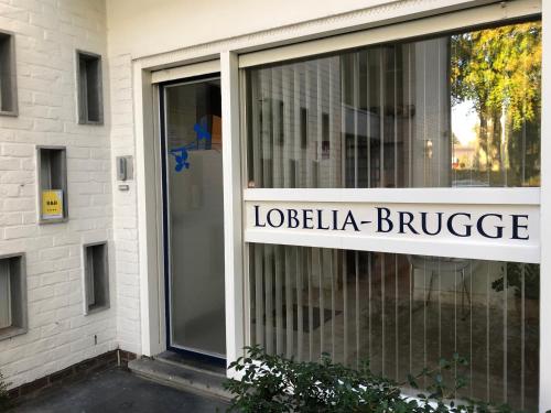 a building with a sign that reads lobelia bridge at B&B Lobelia-Brugge in Bruges