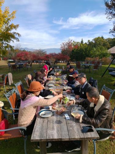 a group of people sitting at a picnic table eating food at Hotel Tae Windsor in Myoko