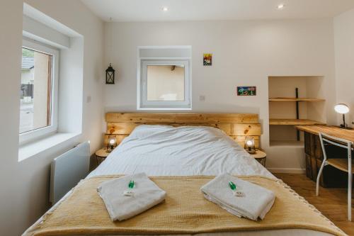 une chambre avec un lit avec deux serviettes dessus dans l'établissement Le Granier, une évasion aux pieds des Bauges 0, à Leysse
