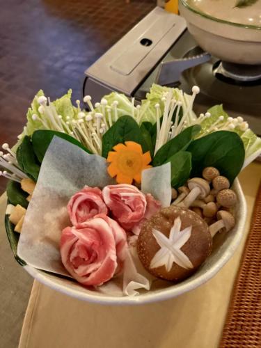 a bowl of food with flowers and other vegetables at Hotel Tae Windsor in Myoko