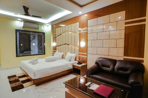- une chambre avec un lit et un canapé en cuir dans l'établissement Prasant Beach Resort Mandarmani, à Mandarmoni