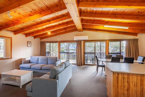 a living room with a couch and a table at Alpine Activity Centre in Jindabyne