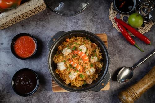 a pan of rice with shrimp and vegetables on a table at Majesty Luxury Prime Cruise by Premier Group in Ha Long