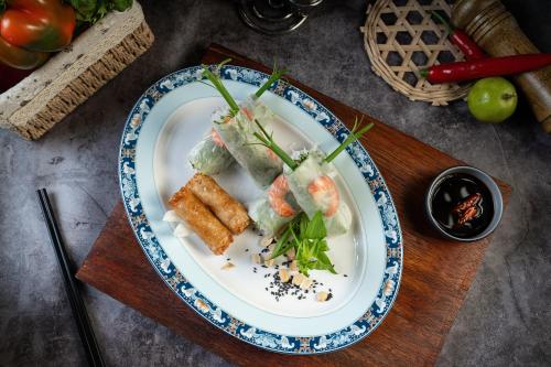 a plate of food with sushi on a table at Majesty Luxury Prime Cruise by Premier Group in Ha Long