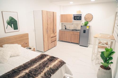 a bedroom with a bed and a kitchen with a refrigerator at Apto 203 - Casa bendita in Medellín