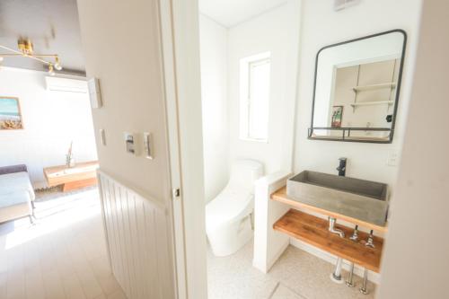a white bathroom with a sink and a mirror at Maison De Vacances Hayama in Hayama
