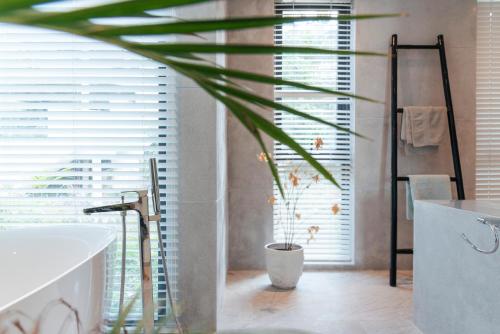 a bathroom with a tub and a potted plant at Seaview Dreamscape Villa in Amphoe Koh Samui