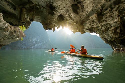 a group of people in kayaks in a cave at Majesty Luxury Prime Cruise by Premier Group in Ha Long