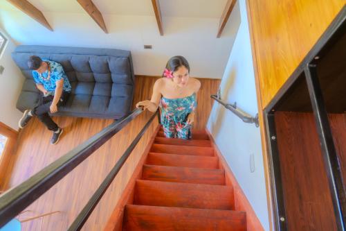 a woman walking down the stairs in a house at Cabañas Tahonga Rapa Nui in Hanga Roa