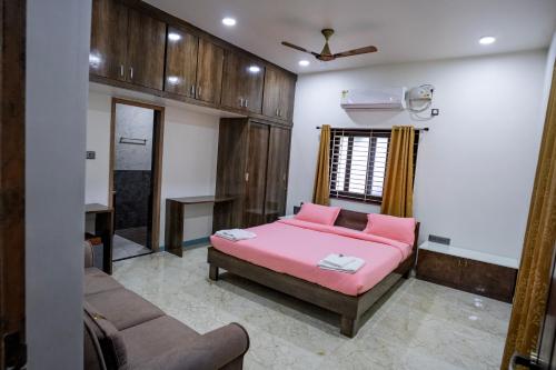 a bedroom with a pink bed and a couch at ARS FARMSTAY in Munirābād