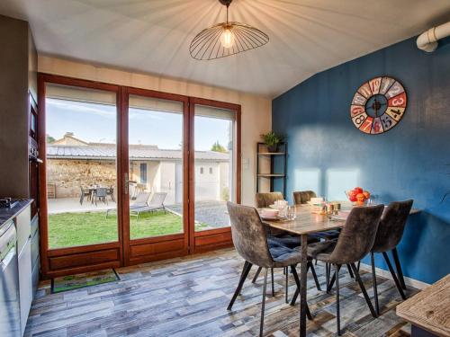 une salle à manger avec une table, des chaises et une horloge dans l'établissement Maison de plain-pied avec jardin privé et terrasse à Cabourg - FR-1-788-40, à Cabourg