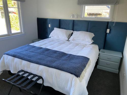 a blue bedroom with a bed with a blue headboard at Home Away From Home on Phoenix in Palmerston North