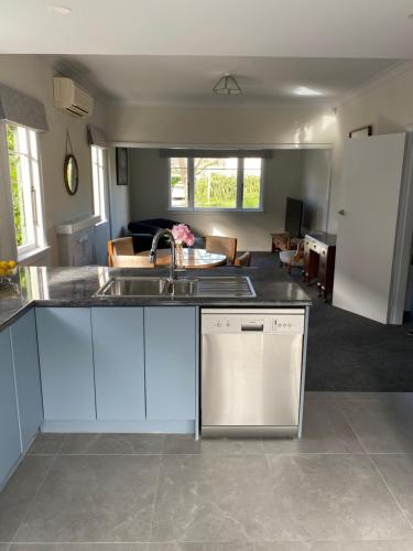 a kitchen with a sink and a living room at Home Away From Home on Phoenix in Palmerston North