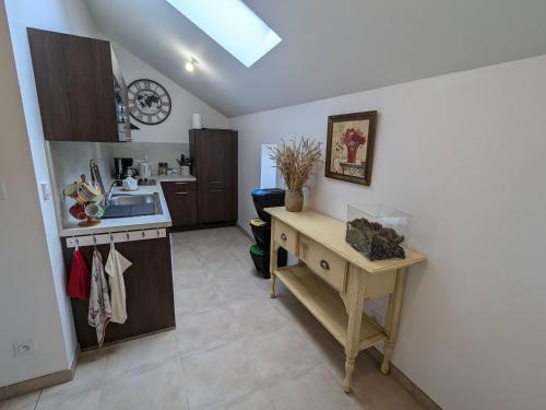 une cuisine avec un évier et une table à l'intérieur dans l'établissement Charmant gîte près d'Orléans avec jardin privatif et parking - FR-1-590-524, à Chaingy