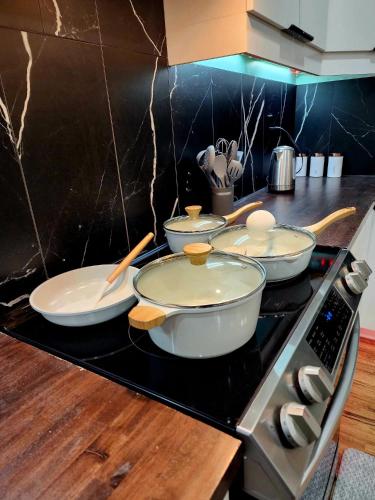 four pots and pans on a stove in a kitchen at Charming & Compact Retreat in St. Albert