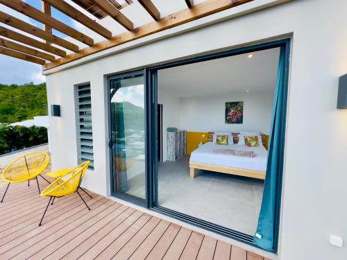 a bedroom with a bed and a sliding glass door at Villa SKY 4 Chambres - Vue sur le Diamant in Morne Blanc