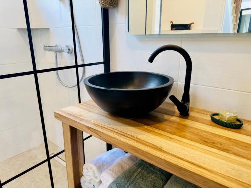 a black bowl on a wooden table in a bathroom at Villa SKY 4 Chambres - Vue sur le Diamant in Morne Blanc