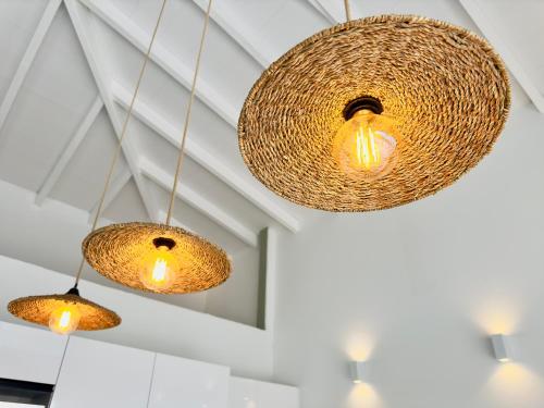 a group of three lights hanging from a ceiling at Villa SKY 4 Chambres - Vue sur le Diamant in Morne Blanc