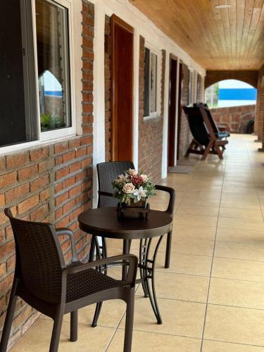 a patio with two chairs and a table with flowers on it at Hotel Posada Doña Celes in Mesa Colorada