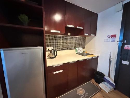 a small kitchen with a sink and a refrigerator at Greenage MingSuite 明绿时代套房 Kota Kinabalu 亚庇市中心 in Kota Kinabalu