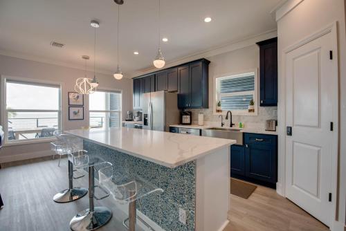 a kitchen with blue cabinets and a large island with bar stools at Ritaville - Monthly Rental in Stock Island