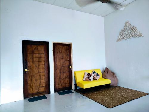 a yellow couch in a room with two doors at SS HOMESTAY2 - Homestay Budget Tanah Merah in Tanah Merah