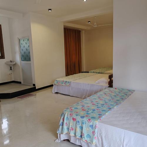 a hotel room with two beds and a window at Aurora Echo Villa in Matara