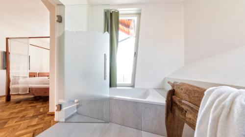 a bathroom with a bath tub and a window at Niedermairhof in Brunico
