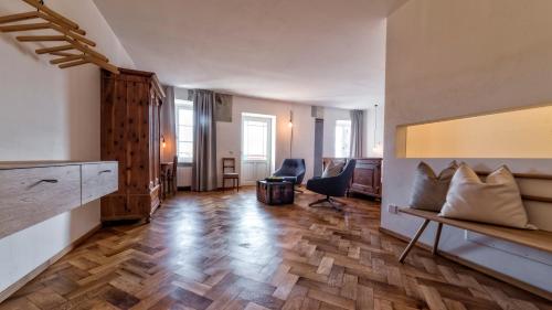 a living room with a wooden floor and a desk at Niedermairhof in Brunico