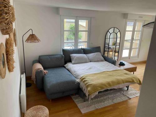 un salon avec un canapé bleu et une table dans l'établissement Duplex avec terrasse face à la cathédrale, à Bayeux