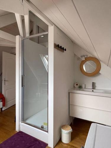 La salle de bains est pourvue d'une porte en verre et d'un lavabo. dans l'établissement Duplex avec terrasse face à la cathédrale, à Bayeux