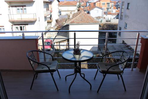 a glass table and two chairs on a balcony at Villa & Apartments Antigona in Ohrid