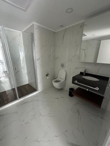 a bathroom with a toilet and a sink and a shower at Grand Sapphire Casino 12 in Iskele