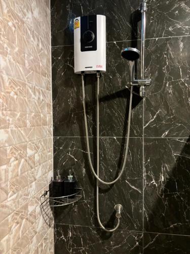 a shower with a soap dispenser on a wall at Blue Aura Pool Villa in Nai Yang Beach