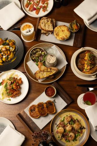 a wooden table with plates of food on it at West Hotel Sydney, Curio Collection by Hilton in Sydney