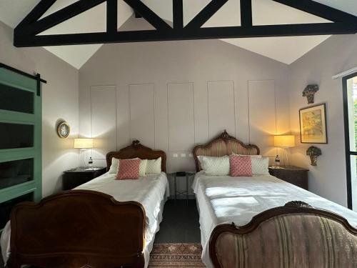 a bedroom with two beds and two chairs at Boutique Hotel La Casona in Valle de Ángeles