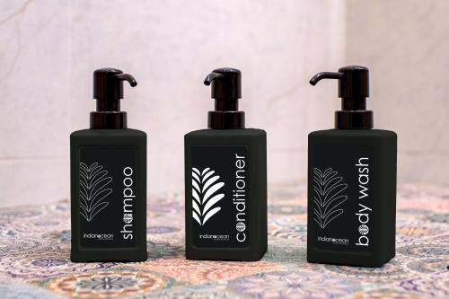 three bottles of hair products sitting on a table at Indian Ocean Lodge in Grand'Anse Praslin