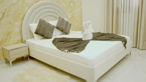 a bedroom with a white bed with a headboard at Locabiss 5, ALMADIES 2 in Rufisque