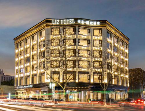 ein großes Gebäude mit seitlicher Beleuchtung in der Unterkunft Meihao Lizi Hotel Taizhou Pozi Street Old Street Store in Taizhou