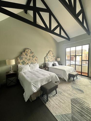 a bedroom with two beds and a large window at Boutique Hotel La Casona in Valle de Ángeles