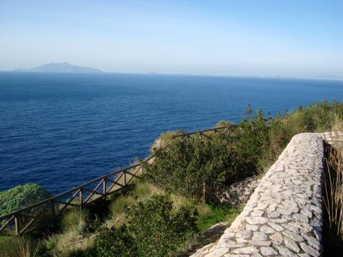 a stairway to the ocean with a stone wall at Villa Eva in Anacapri