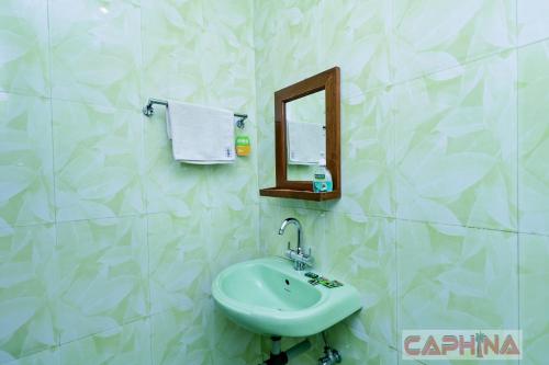 a bathroom with a sink and a mirror at Caphina Coastal Comforts in Benaulim