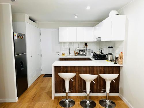 eine Küche mit weißen Schränken und weißen Hockern in der Unterkunft Alojamiento Mama Ocllo in Lima