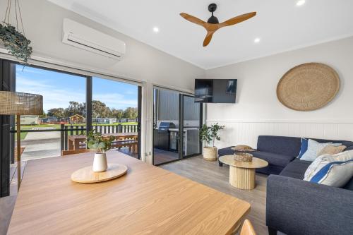 a living room with a blue couch and a table at BIG4 Ingenia Holidays Inverloch in Inverloch