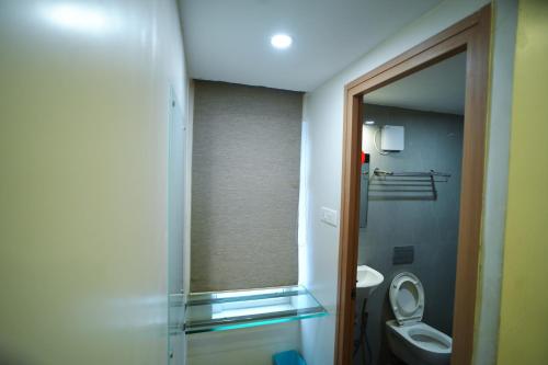 a bathroom with a toilet and a glass shower door at RAAJ PEARL in Chennai